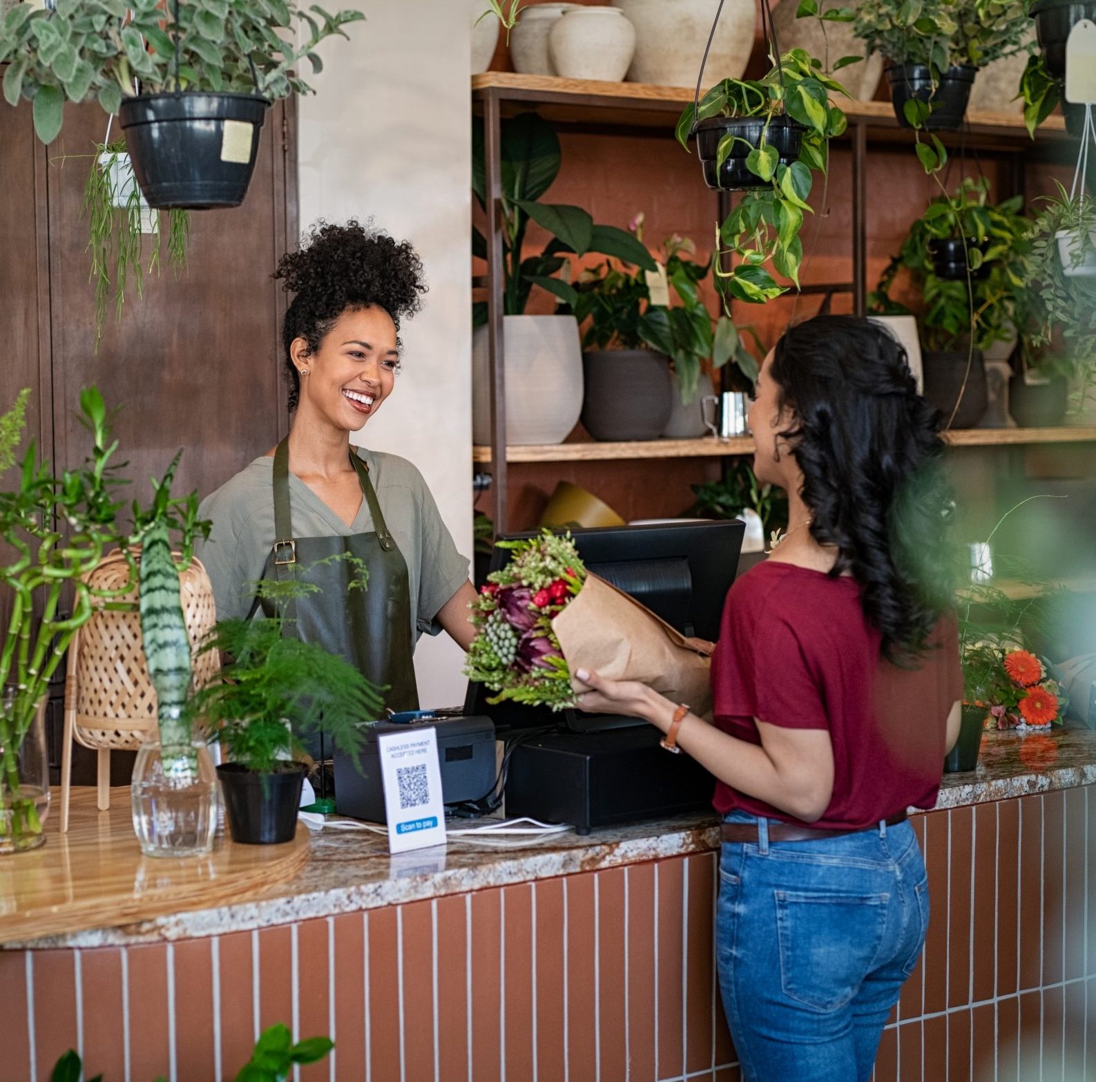 happy florist selling plants and flower to client